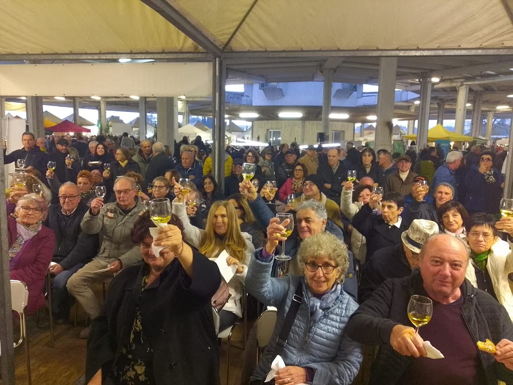 Il pubblico brinda con un calice di vino sotto il tendone della manifestazione