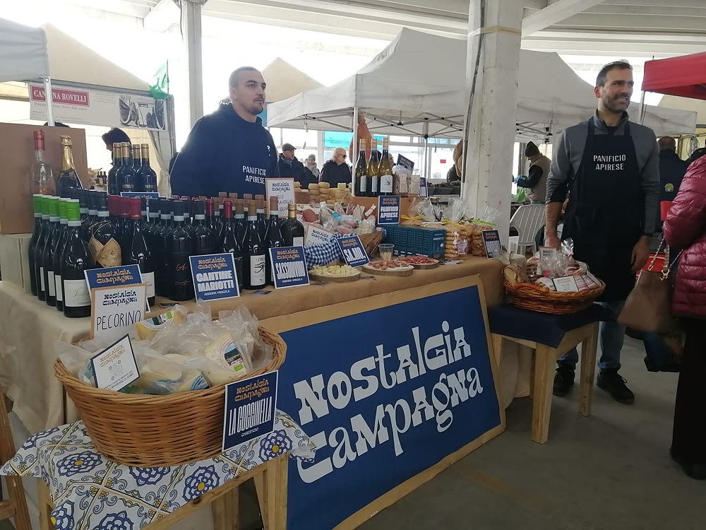 Espositori al proprio stand con vini, salumi e prodotti tipici